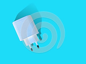 White Travel Charger Adapter isolated on bright turquoise color background. Back side, Top angel view, lay down position