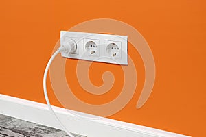 White triple outlet on orange wall