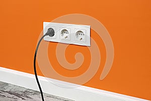 White triple outlet on orange wall