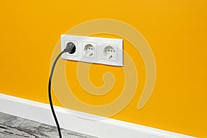 White triple outlet on yellow wall
