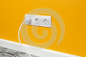 White triple outlet on yellow wall