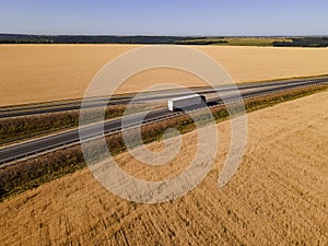 White Truck with Cargo Semi Trailer Moving on Autumn Road. Aerial Top Drone View