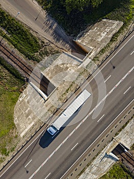 White Truck with Cargo Semi Trailer Moving on Road. Highway intersection junction. Aerial Top View