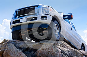 White truck on cliff edge showing undercarriage