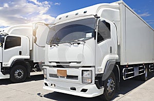 A white truck container on parking at a blue sky. Cargo freight transportation