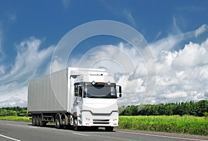 White truck on country highway under blue sky