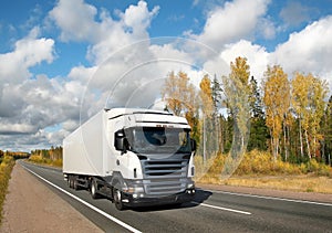 White truck on country highway under blue sky