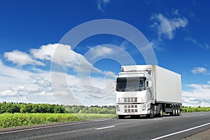 White truck on country highway under blue sky