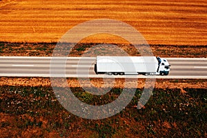 White truck on highway through countryside landscape, aerial shot