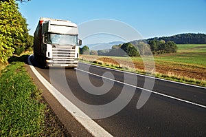 White truck on the road in a rural landscape