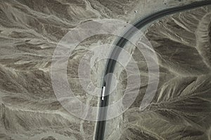 A white truck runs on the pan-American Highway through Nazca desert in Peru.