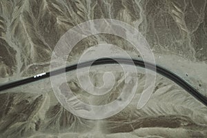 A white truck runs on the pan-American Highway through Nazca desert in Peru.