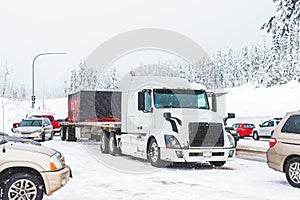 White truck on snow road with traffic jam on snowy day.