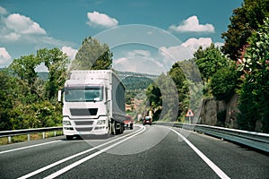 White Truck Or Tractor Unit, Prime Mover, Traction Unit In Motion On Road, Freeway. Asphalt Motorway Highway Against