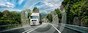 White Truck Or Tractor Unit, Prime Mover, Traction Unit In Motion On Road, Freeway. Asphalt Motorway Highway Against