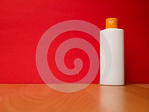 White tube bottle of shampoo, conditioner, mouthwash, on a red background