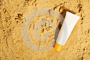 White tube of sunscreen on beach sand. Sun Protection. Top view. Copy space