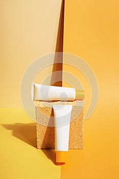 White tubes of sunscreen on orange background. Sun Protection. Copy space