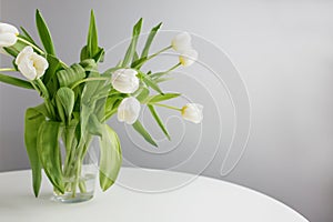 White Tulips Bouquet on White Table Minimalist Decor. Copy space