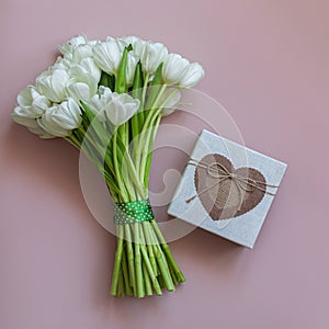 White tulips and gift box on pink background. Spring concept.