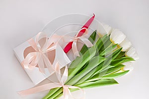 Spring website header template. White tulip black gift box with silver ribbon on light background flat lay. Copy space