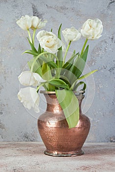 White tulips in old copper vase photo