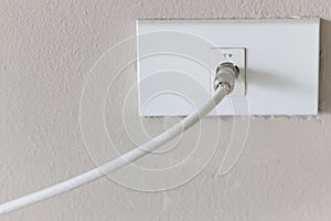 White tv plug on white wall.