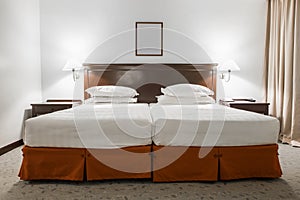 White twin bed with picture frame in hotel room