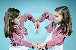 White twins creating heart from hands