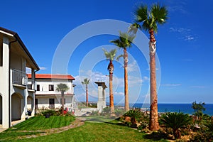 White two-story house with brown roof, green lawn