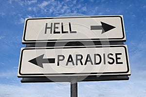 White two street signs with arrow on metal pole with word hell and paradise