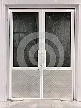 White two-way doors of a closed shop with curtained windows