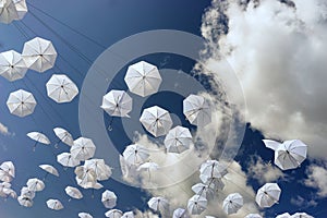 White umbrellas on blue sky background