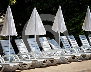 White umbrellas and deck chairs on the beach