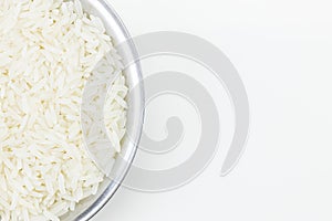 White uncooked Thai Jasmine rice in metal bowl on white background