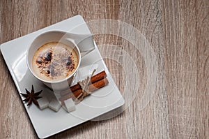 White unusual cup of coffee. Cup on a white rectangular saucer.