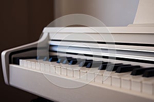 White upright piano. Classic piano keyboard with black and white keys.