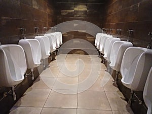 White urinals in the men`s room, the design of white ceramic urinals for men in the men`s room. Public toilet for men, WC. in Spai