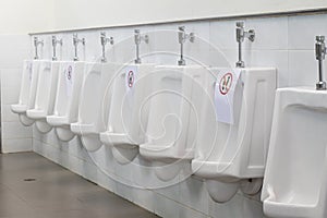 White urinals with symbol disallowing in the men public toilet