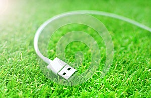 White usb cable on a green grass