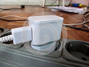 White USB charging for gadgets on a blurred background of the room, close-up