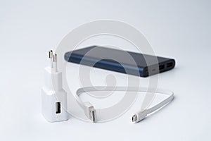 White USB power adapter, cable and blue power bank for divice isolated on a white background