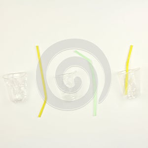 White used dirty plastic disposable tableware, cups and straw for drinks, white background, garbage and pollution environmental