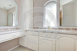 White vanity in soft pink bathroom