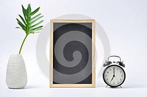 white vase with ablackboard and ablack clock photo