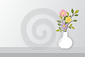 White Vase with beautiful colorful flowers and plants on gray table and white wall background..