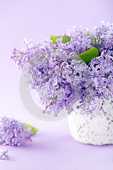 White vase with a bouquet of lilacs