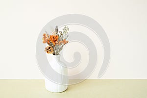 White vase of dry flower on table. white ivory background