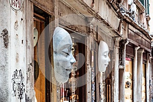 White venetian masks hanging in front of touristic shop in Venice