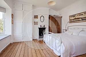 White victorian bedroom with exposed floorboards